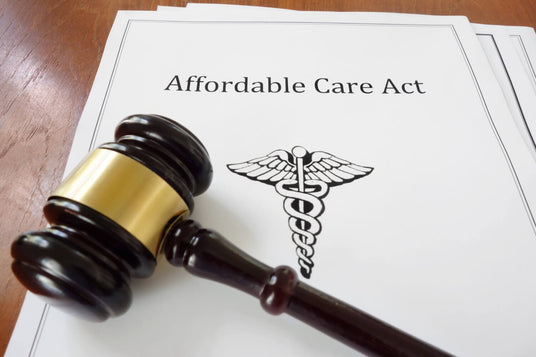 A gavel rests on a document titled Affordable Care Act with a medical caduceus symbol.