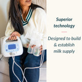 A woman seated indoors holds a breast pump setup with a white electric pump and clear collection bottles. Text on the right reads, 'Superior technology Designed to build & establish milk supply.