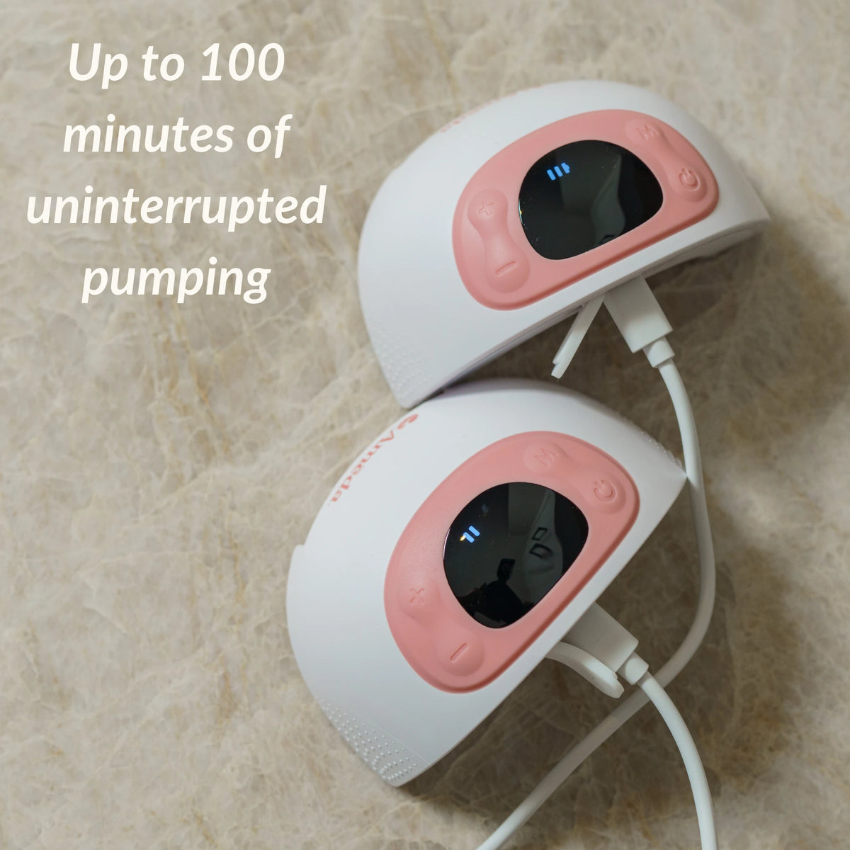 Two Ameda GLO wearable pumps connected to charging cables, illustrating up to 100 minutes of uninterrupted pumping