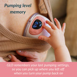 Close-up of Ameda GLO pump display on a mother's chest with toddler's hand reaching toward it, illustrating pumping level memory feature