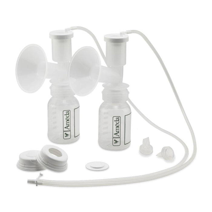 A white breast pump kit featuring two clear collection bottles with measurement markings. Each bottle has a white funnel and a white cap. There are two flexible tubes connecting the funnels to the bottles. Nearby, several white circular attachments and a small white disc are arranged on a white background, which includes a connector piece. The branding on the bottles reads "Ameda."